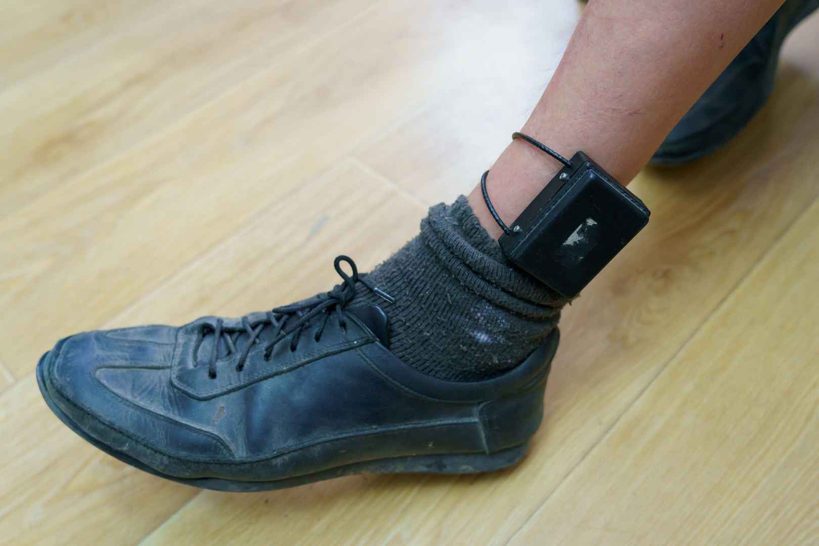 Brățară electronică de monitorizare la glezna unei persoane aflate în arest la domiciliu