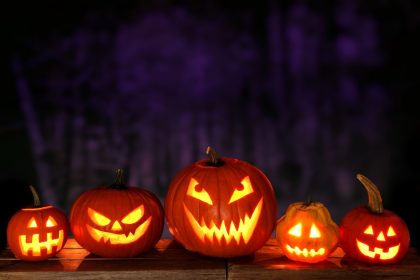 Dovleci sculptați cu lumânări aprinse în interior, decor tradițional de Halloween