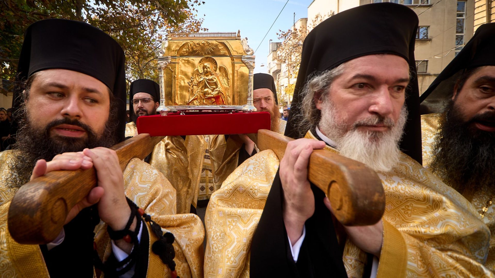 Preoți ortodocși poartă racla cu moaștele Sfântului Dimitrie cel Nou în procesiunea Calea Sfinților, pe străzile din jurul Catedralei Patriarhale din București