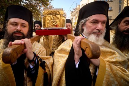 Preoți ortodocși poartă racla cu moaștele Sfântului Dimitrie cel Nou în procesiunea Calea Sfinților, pe străzile din jurul Catedralei Patriarhale din București