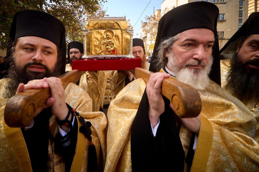 Preoți ortodocși poartă racla cu moaștele Sfântului Dimitrie cel Nou în procesiunea Calea Sfinților, pe străzile din jurul Catedralei Patriarhale din București