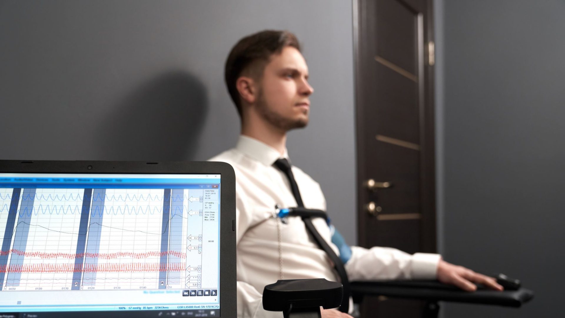 Persoană conectată la senzorii unui aparat poligraf în timpul unui test cu detectorul de minciuni
