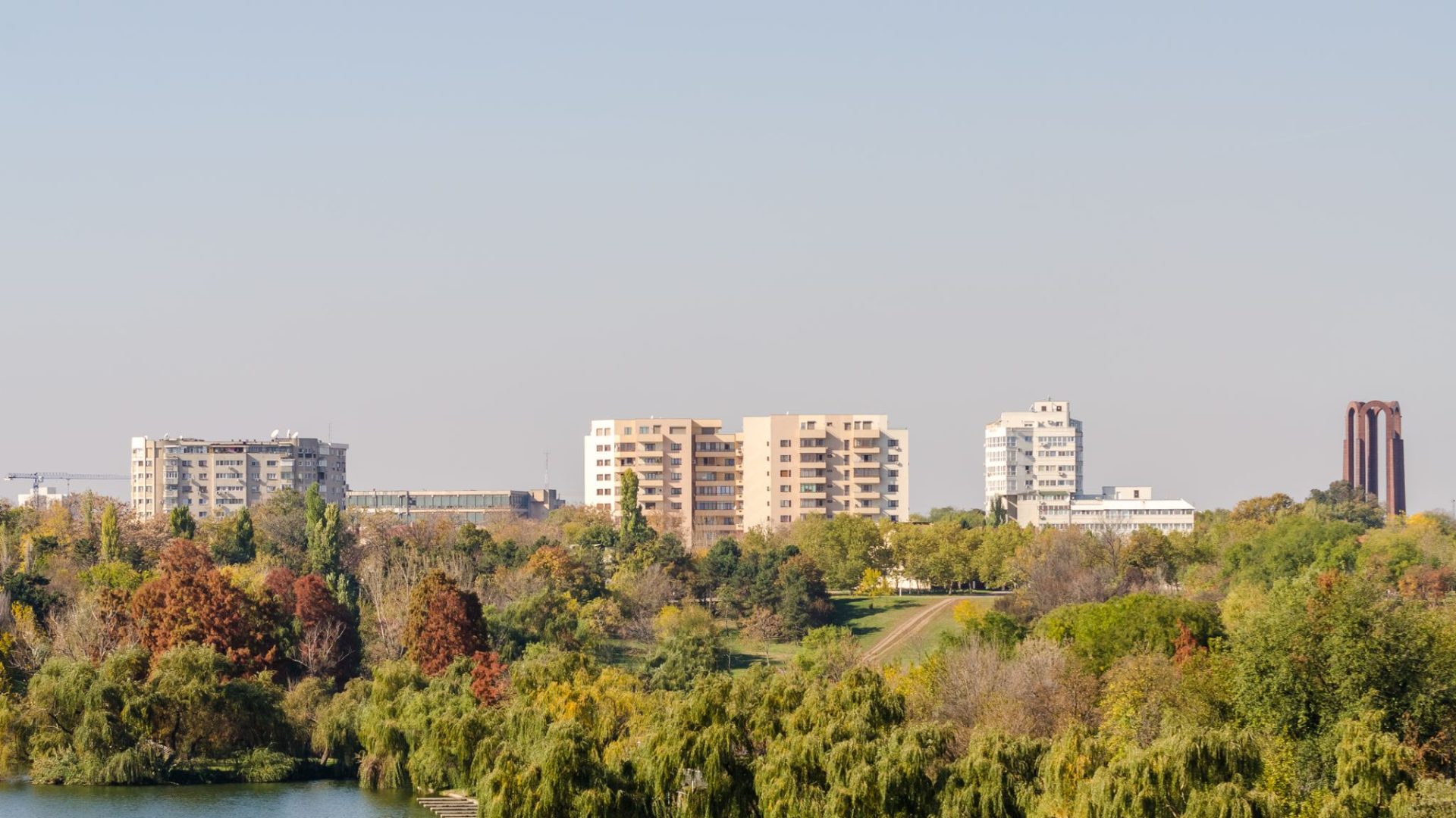 Stradă cu frunze căzute și oameni îmbrăcați gros într-o dimineață rece de toamnă târzie