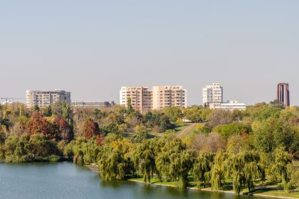 Stradă cu frunze căzute și oameni îmbrăcați gros într-o dimineață rece de toamnă târzie